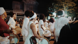 Festa brasileira. Pessoas de branco tocando tambor.